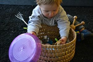 Imagen de bebé explorando una cesta del tesoro